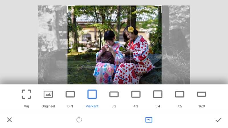 Twee personen met kimono's zitten buiten, de afbeelding wordt bewerkt met een vierkant formaat, bomen en een gebouw op de achtergrond.