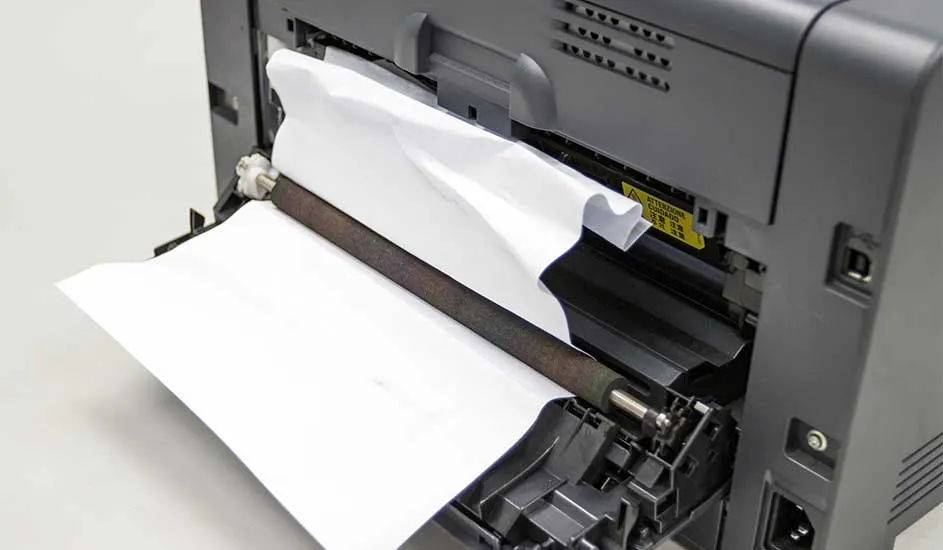 Een grijze printer met wit papier dat er half uit komt, toont de interne mechanismen.