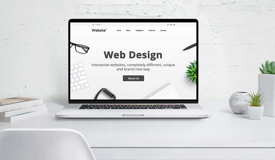 Open laptop op wit bureau toont “Web Design” website, omringd door boeken en kleine groene planten tegen lichte muur.