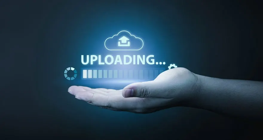 Main blanche tenant une icône de nuage, une barre de chargement, et le mot "UPLOADING..." sur fond bleu foncé.