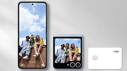 Two smartphones, one folded, and a white card are on a gray surface. The phones display an image of people with a sky background.