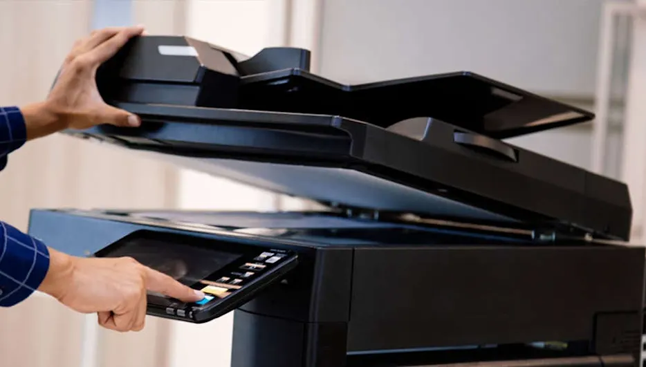 Een zwarte printer met een open klep en een bedieningspaneel dat wordt ingedrukt. Lichte achtergrond.