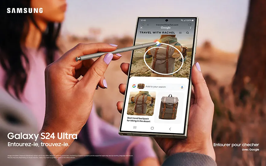 Main tenant un smartphone Samsung affichant une recherche Google pour un sac à dos de voyage. Un stylet pointe l'image du sac.