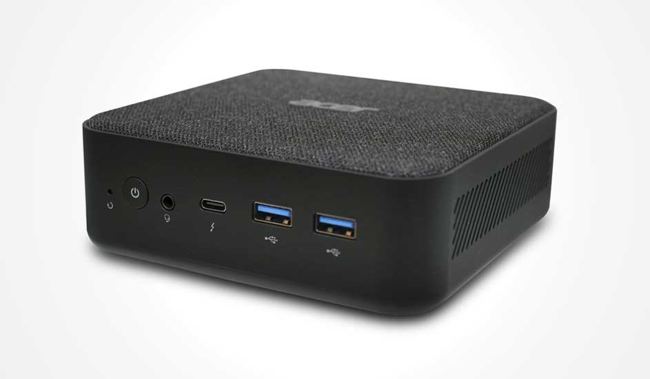 Un mini-PC noir compact avec un dessus en tissu et plusieurs ports à l’avant, dont USB et audio.