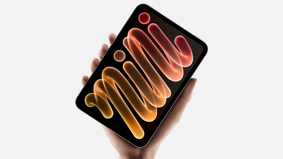 A hand holds a black tablet displaying a glossy, colourful wave pattern in warm orange, red and yellow tones against a light background.