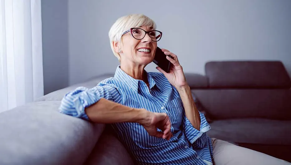 Une femme téléphone tranquillement assise sur un canapé