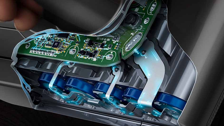Vue rapprochée d'un appareil avec carte de circuit vert et batteries bleues, intérieur gris.