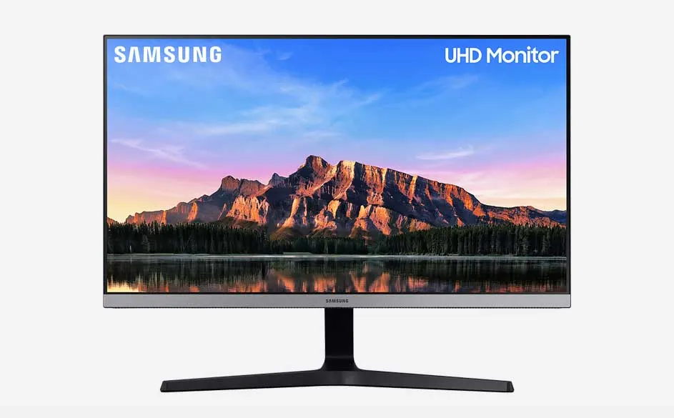Un écran UHD Samsung affiche un paysage montagneux sous un ciel bleu et rose, reflété dans l'eau. Le pied est noir.