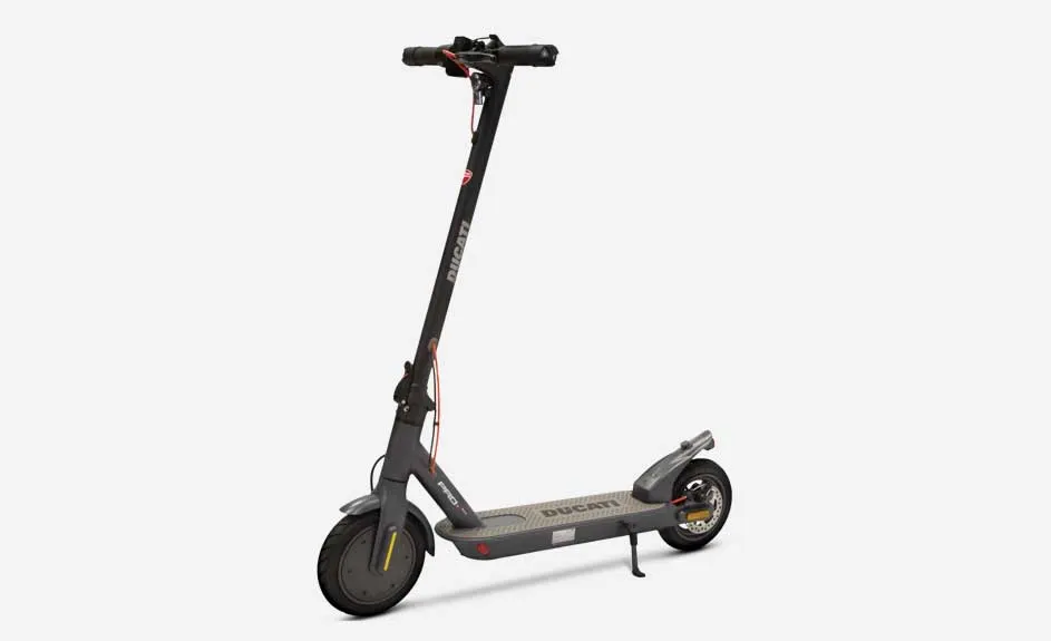 Une trottinette électrique grise avec le logo "Ducati" sur le guidon et le plateau, sur fond blanc.