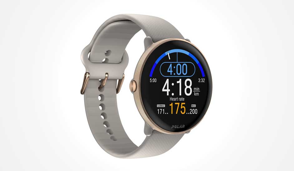 Une montre Polar à bord doré affiche l’heure, la fréquence cardiaque et des infos sportives sur écran noir, bracelet gris.