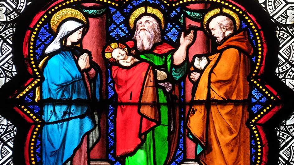 Kleurrijk glas-in-loodraam met drie figuren: een in blauw, één met een baby in rood en groen, en één in oranje.