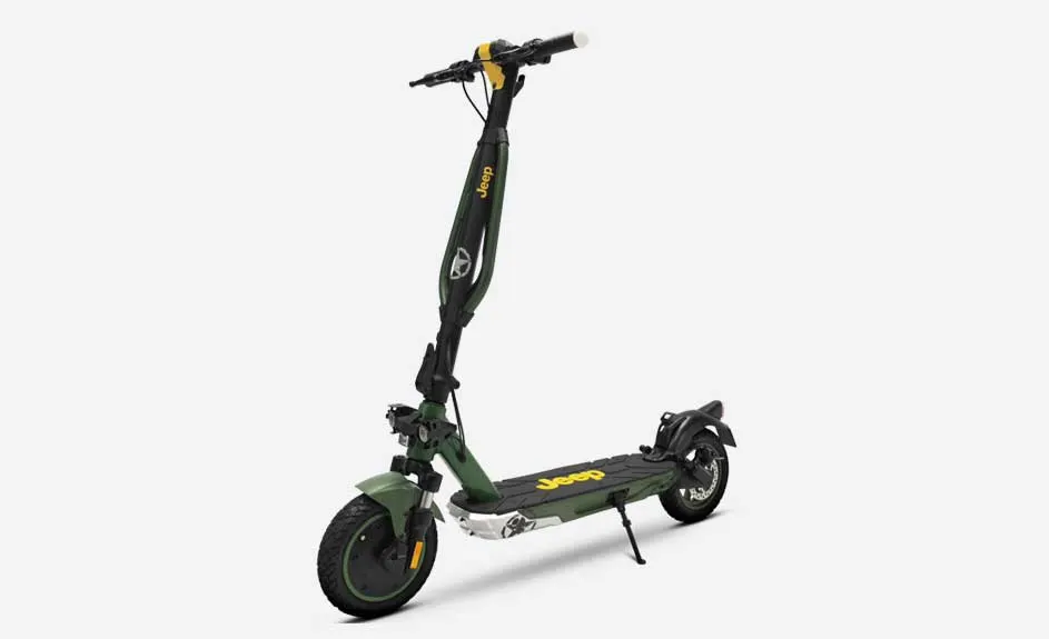Trottinette électrique verte et noire avec accents jaunes sur fond blanc. La béquille est déployée.