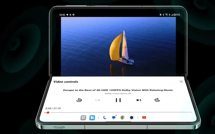 Een opvouwbare smartphone toont een video van een zeilboot op blauw water. De videobediening is zichtbaar onder het scherm.