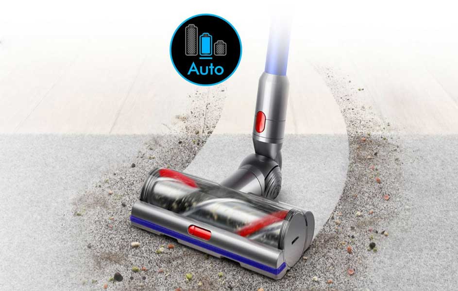 Aspirateur gris sur sol gris sale. Tête transparente avec brosse rouge. Icône "Auto" et batterie visible.