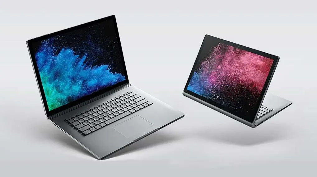 Twee zilverkleurige laptops staan op een witte achtergrond. De schermen tonen blauwe en roze abstracte patronen.