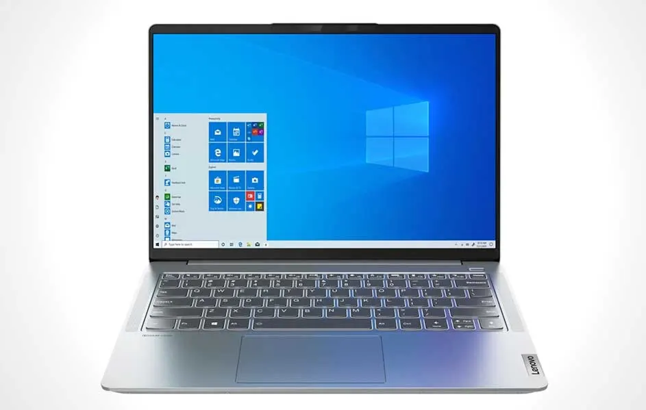 Un ordinateur portable Lenovo argenté est ouvert, affichant le menu Windows sur un fond d'écran bleu.