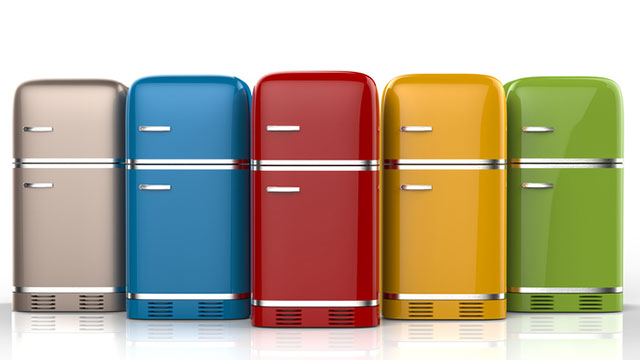 Vijf koelkasten in beige, blauw, rood, geel en groen staan naast elkaar op een witte ondergrond.