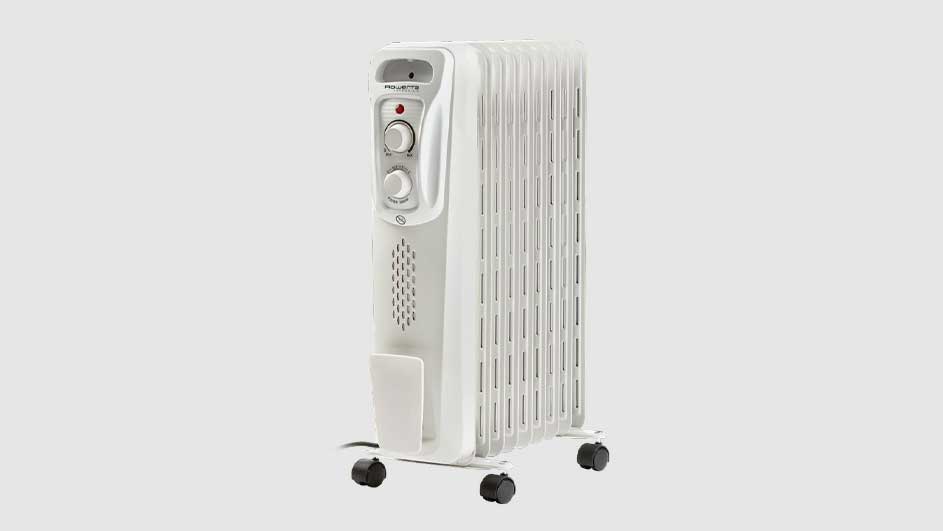 Radiateur à bain d'huile blanc sur fond blanc. Il a des ailettes verticales et des molettes de réglage sur le côté.