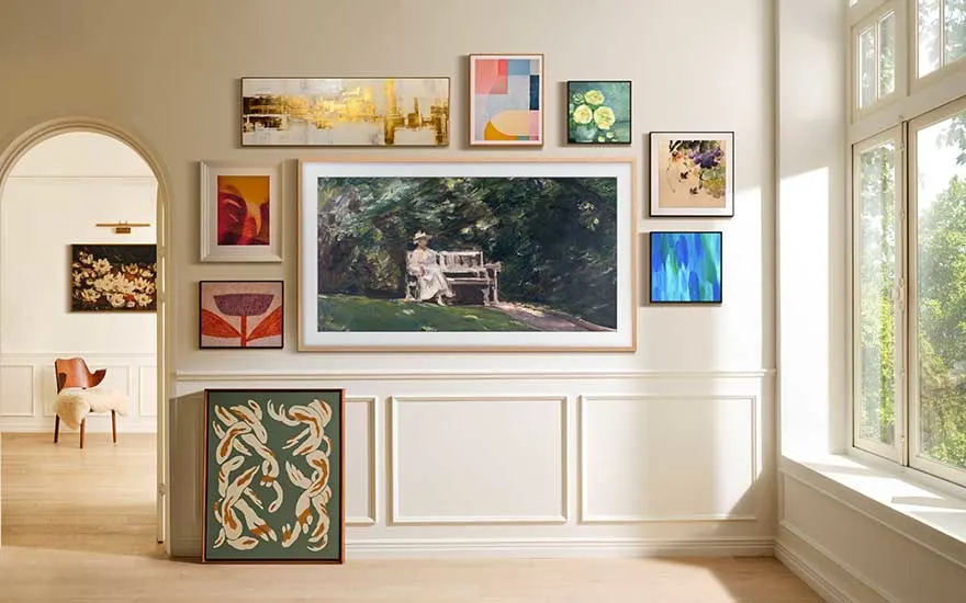 Un mur élégamment décoré présente plusieurs tableaux, dont une peinture centrale d’une femme assise sur un banc dans la lumière.