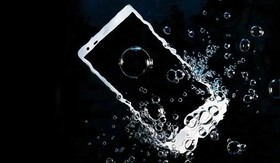 Een smartphone zinkt in het water, omringd door luchtbellen, merk is niet zichtbaar.