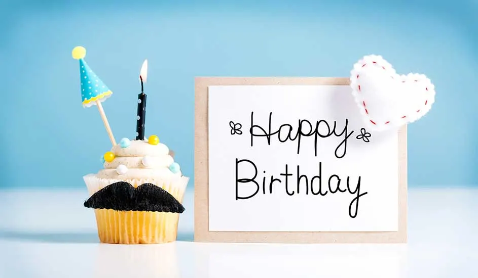 Gâteau avec bougie, chapeau, et moustache noire. Panneau "Happy Birthday" et cœur blanc sur fond bleu clair.