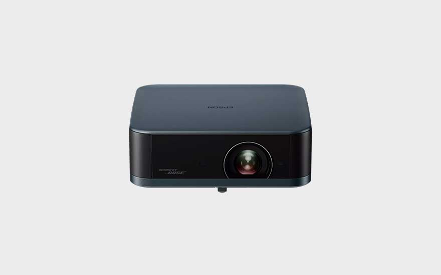 Projecteur Epson sombre au design rectangulaire épuré, lentille centrale, mention audio Bose et fond de studio minimaliste.