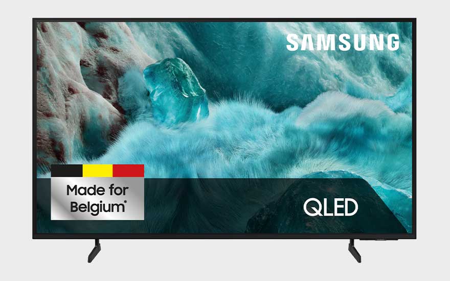A Samsung QLED TV displays icy blue waves and carries a label stating that it is made for Belgium.