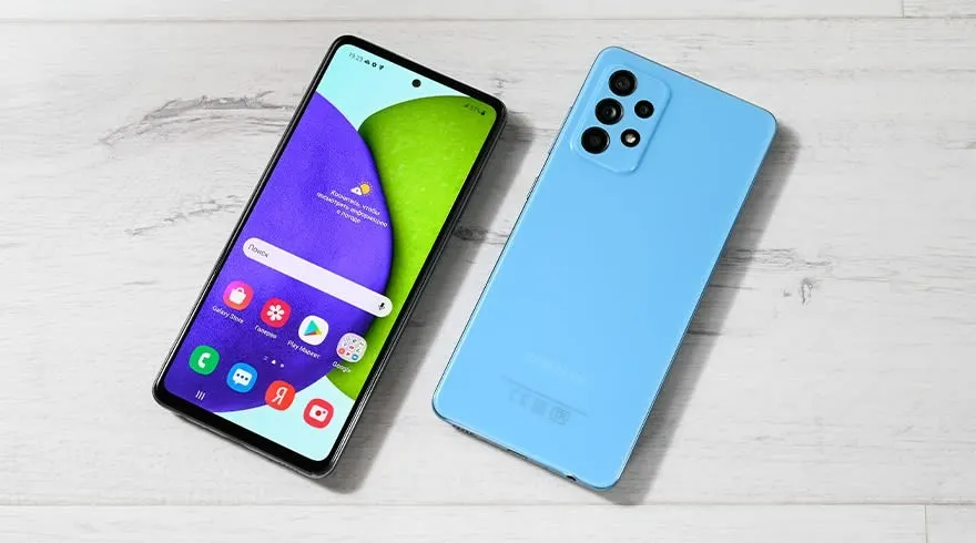 Twee smartphones op een witte houten ondergrond. De ene toont apps op een scherm met paarse en groene achtergrond, de andere is lichtblauw met camera's.