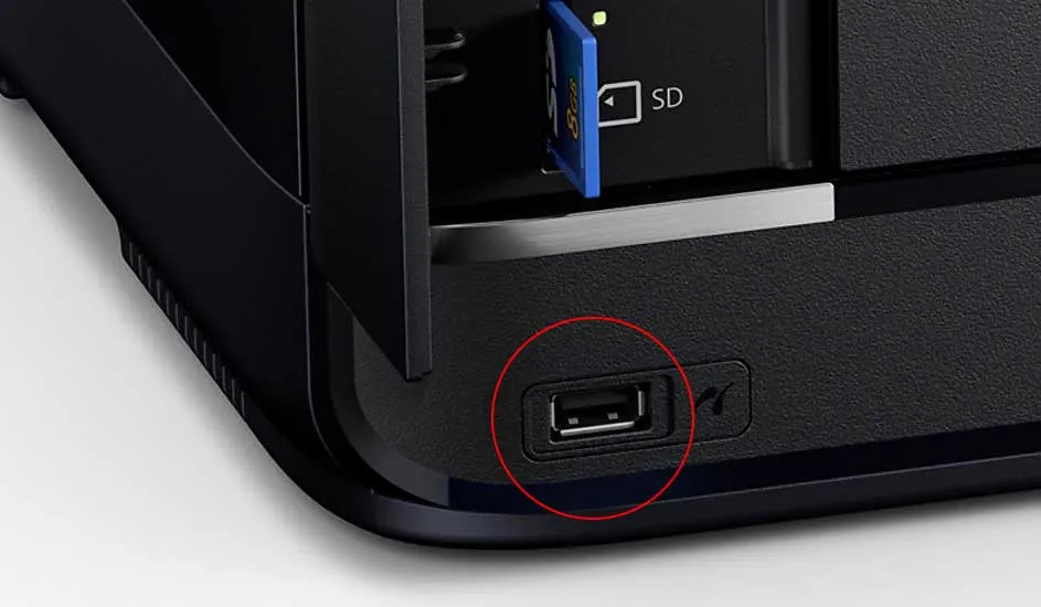 Gros plan sur une imprimante noire montrant un lecteur de carte SD et un port USB, ce dernier étant mis en évidence par un cercle rouge.