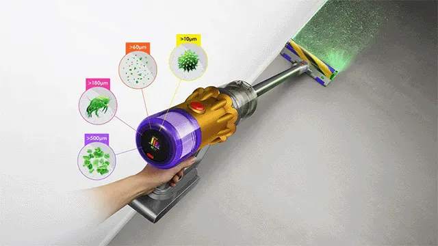 Un aspirateur doré et violet est utilisé sur un sol gris, avec des particules illustrées et une lumière verte.