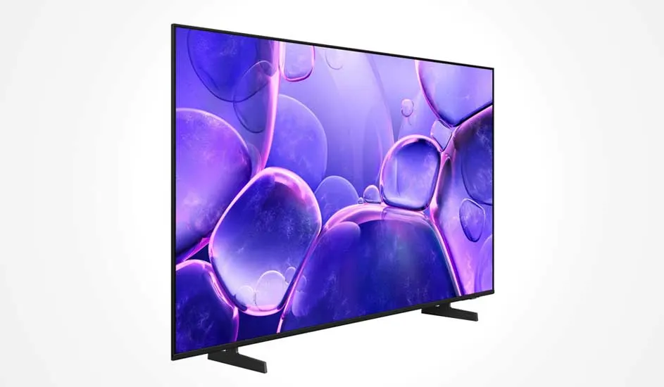 Une télévision à cadre noir fin posée sur deux pieds larges affiche un motif abstrait de bulles violettes et bleues à l’écran.