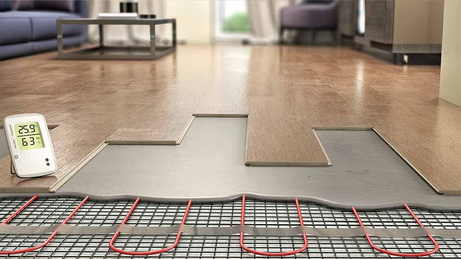 Installation de chauffage au sol. Tapis chauffant rouge sous des planches de bois. Un thermostat indique 25.9 degrés.