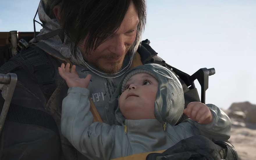 Une capture d'écran du jeu vidéo Death Stranding montrant un personnage principal en équipement futuriste tenant un bébé dans une capsule protectrice. L'arrière-plan révèle un paysage désolé post-apocalyptique.