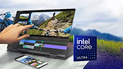Een laptop toont videobewerkingssoftware met een fietstocht. Een smartphone en Intel Core Ultra-doos staan op een tafel tegen een bergachtige achtergrond.