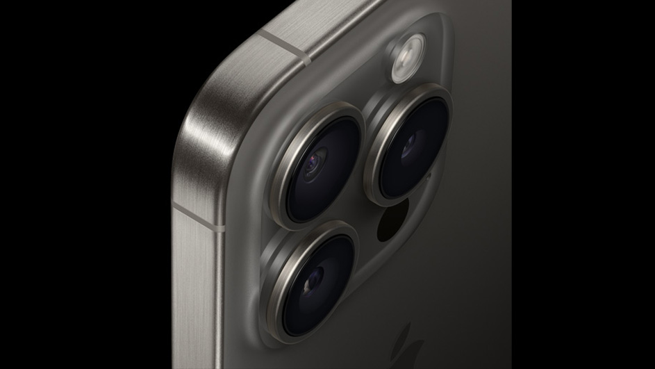 Zilverkleurige smartphone met drie cameralenzen en een flitser op een zwarte achtergrond.