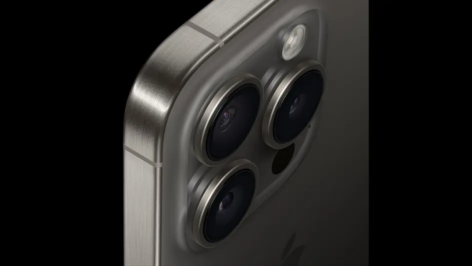 Gros plan d'un téléphone gris avec trois objectifs de caméra circulaires et un flash sur un fond noir.