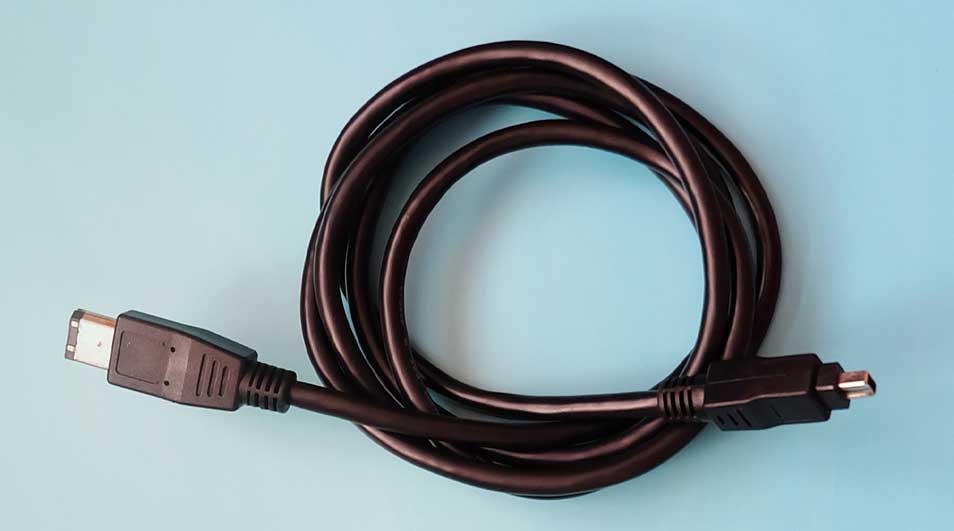 Un câble noir enroulé sur un fond bleu clair. Chaque extrémité a un connecteur différent.