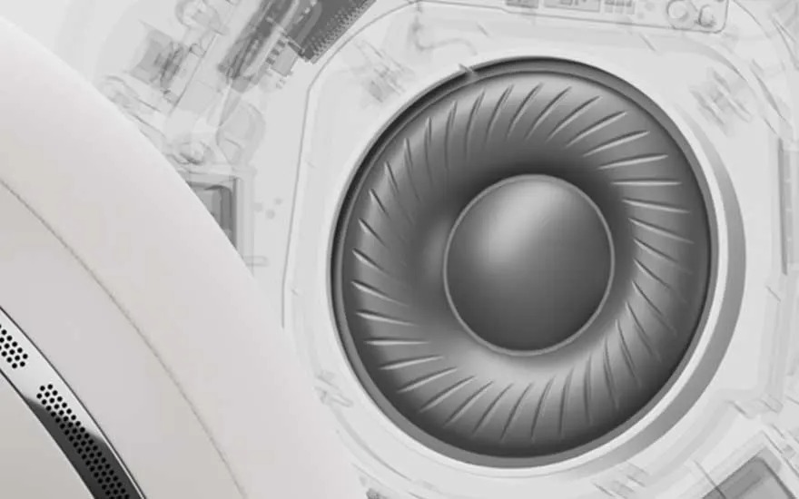 Gros plan sur un casque audio blanc et gris avec un haut-parleur rond visible.