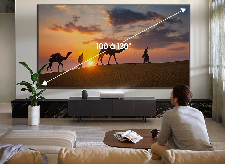 Salon avec projecteur affichant un paysage désertique au coucher du soleil. Un meuble noir supporte le projecteur.