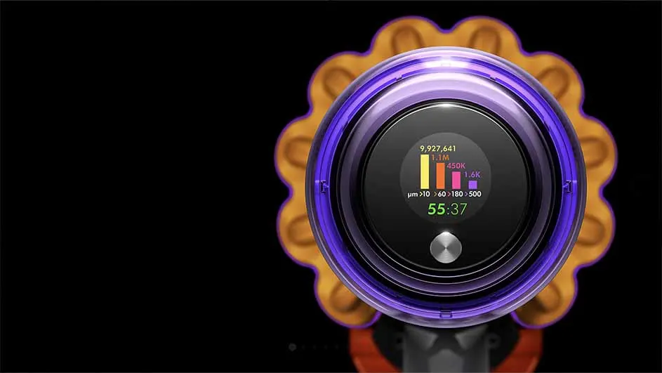 Aspirateur violet et or avec un écran affichant des statistiques et un minuteur sur fond noir.
