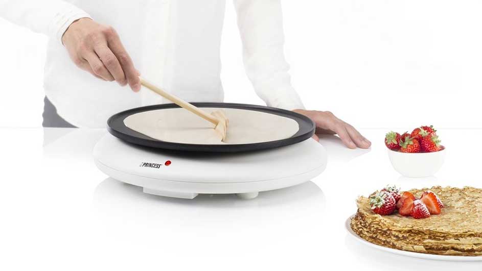 Pannenkoeken worden gemaakt op een wit toestel met aardbeien.