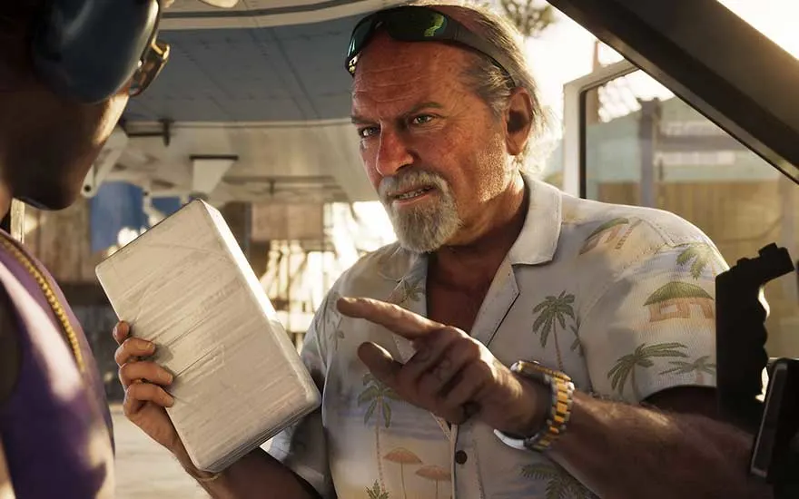 An older man in a tropical shirt stands by a plane, holding a wrapped brick-like package while speaking seriously.