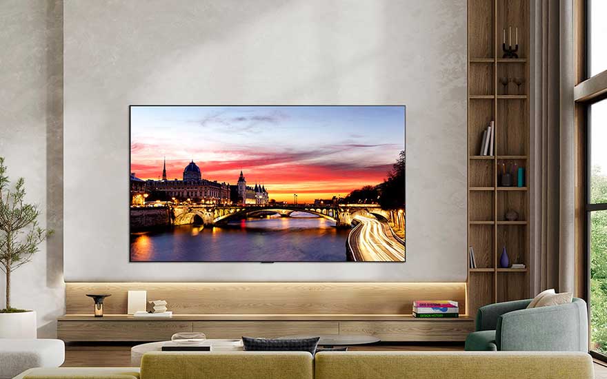 Salon moderne avec grand téléviseur mural affichant une ville au coucher du soleil, meubles en bois, canapés et hautes fenêtres.