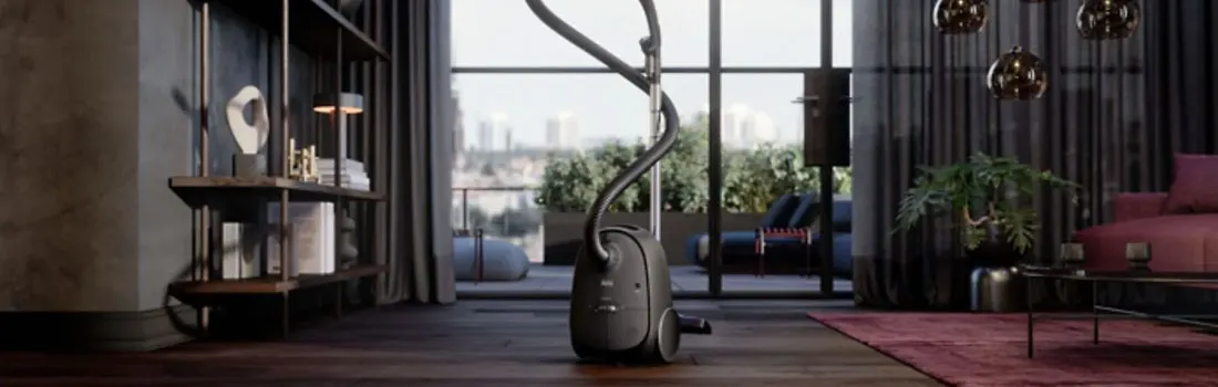 A black garment steamer stands on a wooden floor in a room with a shelf, curtains, and a view of trees and buildings.