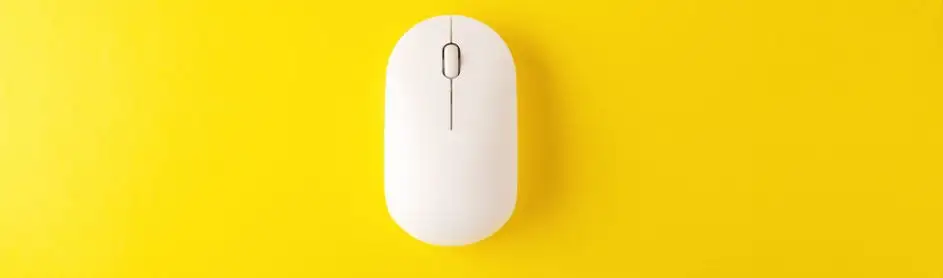 Een witte computermuis ligt op een heldergele achtergrond. De muis is verticaal georiënteerd.