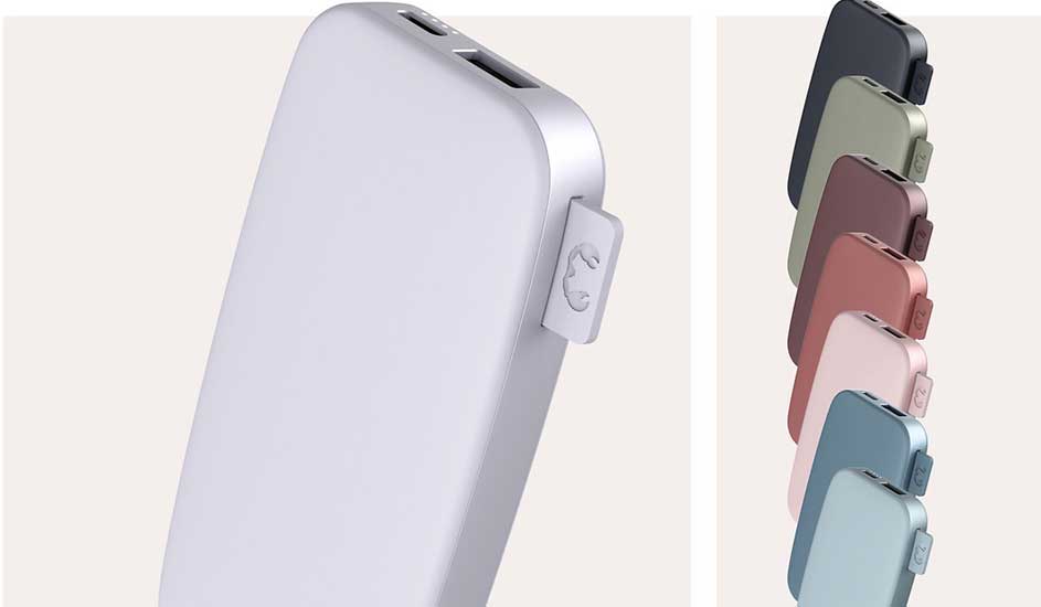 Een close-up van een witte powerbank met aansluitingen, samen met rijen powerbanks in diverse pastelkleuren op een zachte achtergrond.