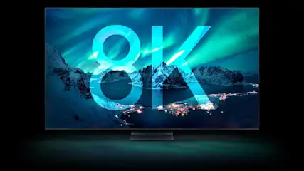 Écran TV 8K affichant un paysage de montagnes enneigées sous une aurore boréale, avec le texte "8K" superposé.