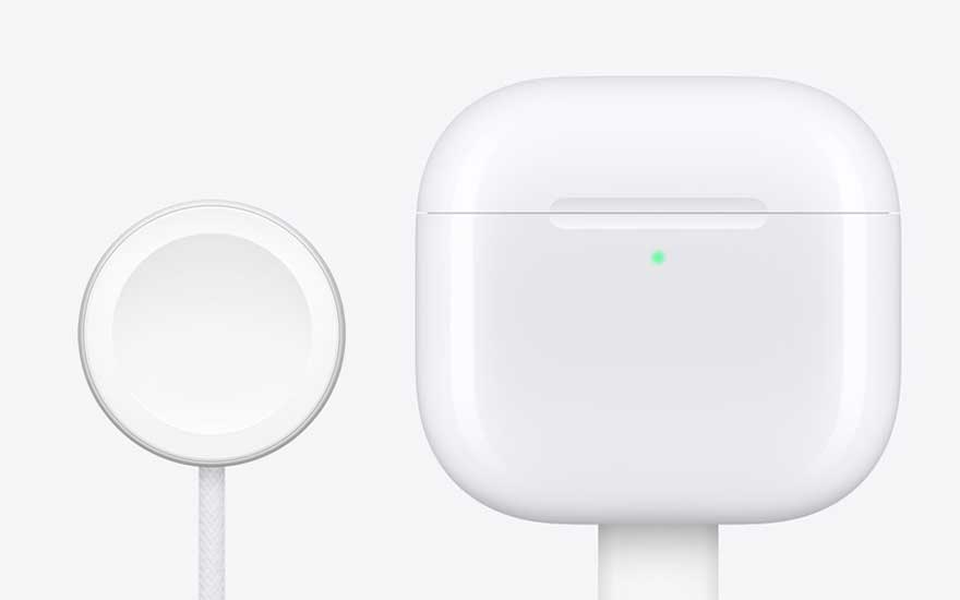 Gros plan d’un galet de charge sans fil blanc à côté d’un boîtier rectangulaire, tous deux au design épuré sur un fond très clair.