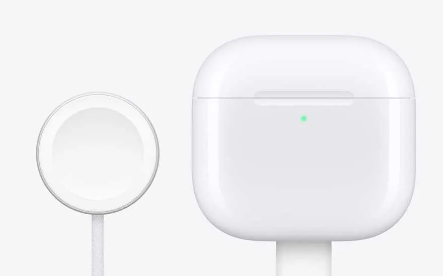 Gros plan d’un galet de charge sans fil blanc à côté d’un boîtier rectangulaire, tous deux au design épuré sur un fond très clair.