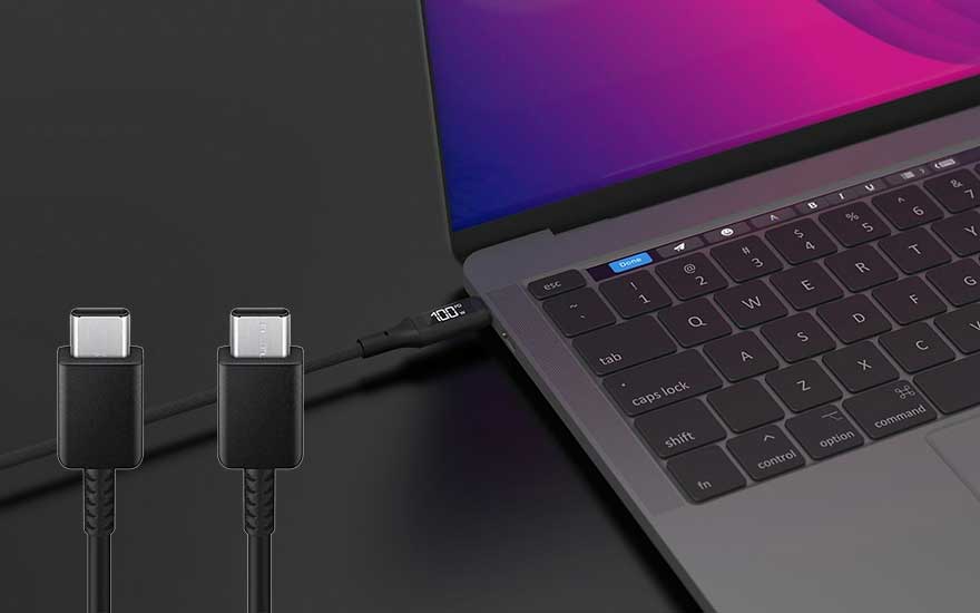 Een zwarte USB-C-kabel is aangesloten op een laptop, die 100% opgeladen is. Het laptopscherm is paars.